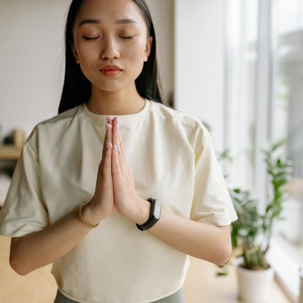 Person meditating peacefully in a bright, minimalist room.